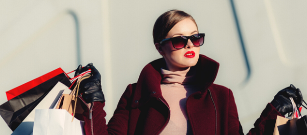 woman in sunglasses holding shopping bags