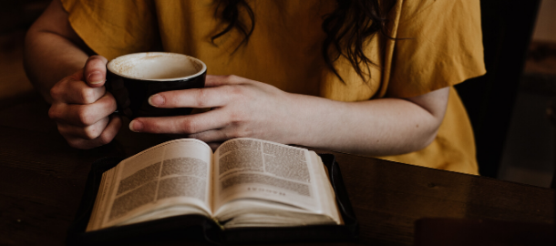 woman with coffee reading a book