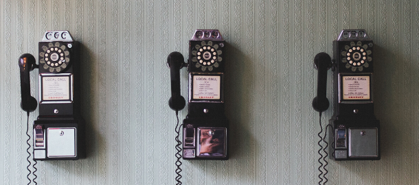 3 old school phones on the wall